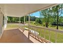 Spacious covered porch showcases a scenic view of a lush yard and serene lake at 9180 Shiloh Dr, Villa Rica, GA 30180