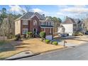 Brick front home boasts a manicured lawn and attached two-car garage at 1039 Ashfern Walk, Woodstock, GA 30189