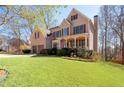Charming home featuring lush green lawn, mature trees, and beautiful landscaping at 5383 Fawn Meadow Ln, Powder Springs, GA 30127