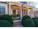 Inviting front porch features classic columns, an American flag, and manicured shrubs at 5383 Fawn Meadow Ln, Powder Springs, GA 30127