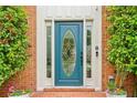 Close up of front door with decorative glass, sidelights, and potted flowers at 828 Guinevere Sw Way, Lilburn, GA 30047