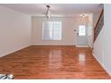Open-concept living room with hardwood floors, a staircase, and ample natural light from a window and a door at 4645 Valais Ct # 89, Alpharetta, GA 30022