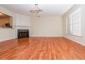 Bright living room boasts hardwood floors, a cozy fireplace, and a large window, creating an inviting space at 4645 Valais Ct # 89, Alpharetta, GA 30022