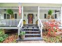 Inviting front porch with decorative plants and an American flag at 5500 Georgetown Sw Trce, Lilburn, GA 30047