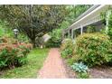 Landscaped brick walkway leading to a charming home with lush greenery at 5500 Georgetown Sw Trce, Lilburn, GA 30047