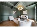 Stylish living room with dark green walls, coffered ceiling, hardwood floors, and elegant furnishings at 111 Carter Ln, Canton, GA 30115