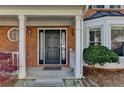 Close-up of the front door with white columns and brick detail, complemented by a landscaped garden area at 2940 Abbotts Pointe Dr, Duluth, GA 30097