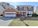 Inviting two-story brick home featuring an attached garage, front yard, and a welcoming entrance with a unique bay window at 2940 Abbotts Pointe Dr, Duluth, GA 30097