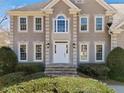 Elegant two-story home entrance with stone steps and meticulous landscaping at 918 Fox Hollow Way, Marietta, GA 30068