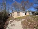 View of a single-story home with boarded-up windows and a concrete walkway leading to the front entrance at 1425 Rome Dr, Atlanta, GA 30314