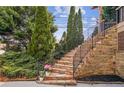 Elegant stone staircase leading to the front entrance, framed by mature trees and decorative landscaping at 1211 Thornwell Ne Dr, Brookhaven, GA 30319
