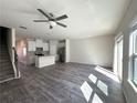 Bright, open living area with hardwood floors, a ceiling fan, and a view of the modern kitchen at 5432 Plain Field Ln, Lilburn, GA 30047
