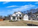 Charming two-story home with a light brick facade, covered entryway, and attached two-car garage, surrounded by a green lawn at 4732 Cooling Water Cir, Powder Springs, GA 30127