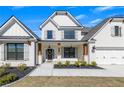 Inviting two-story home featuring light brick, a covered porch with wooden columns, and manicured landscaping adding to its curb appeal at 4732 Cooling Water Cir, Powder Springs, GA 30127