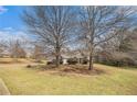 Beautifully landscaped front yard featuring mature trees framing the home's facade at 109 Melrose Creek Dr, Stockbridge, GA 30281
