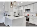 Modern white kitchen with stainless steel appliances, quartz countertops, and stylish pendant lighting at 1101 Juniper Ne St # 519, Atlanta, GA 30309