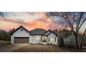 Charming home with a brick exterior, two-car garage, and landscaped front yard at sunset at 1090 Compton Way, Suwanee, GA 30024