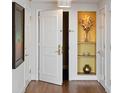 Elegant entryway with a white door, hardwood floors, and a built-in shelf displaying decorative items at 75 14Th Ne St # 3430, Atlanta, GA 30309