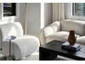Comfortable living area with stylish white chairs and a dark coffee table, bathed in natural light at 75 14Th Ne St # 3430, Atlanta, GA 30309