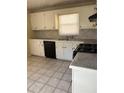 Traditional kitchen with white cabinets, black appliances, and tiled floors at 1415 Dodson Sw Dr, Atlanta, GA 30311