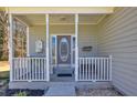 Inviting front porch with white railing, decorative columns, charming decorations, and a glass-paneled front door at 300 The Esplanade Se Way, Loganville, GA 30052