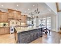 Spacious kitchen featuring a large granite island, custom cabinets, and stainless steel appliances at 6950 Kettering Ln, Suwanee, GA 30024
