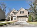 Attractive two-story home boasts brick facade, manicured lawn, and a two-car garage at 1300 Winfair Ne Ln, Brookhaven, GA 30329