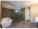Modern bathroom with a glass-enclosed shower, a soaking tub, and stylish gray tiling at 263 Ohm Ave, Avondale Estates, GA 30002