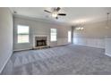 Spacious living room featuring plush gray carpet, a stone fireplace, and abundant natural light streaming through the windows at 266 Eva Ne Way, Cartersville, GA 30121