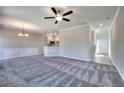Open-concept living area with modern gray carpet, complemented by a ceiling fan and elegant lighting fixtures at 266 Eva Ne Way, Cartersville, GA 30121