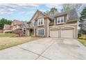 Attractive two-story home with a stone facade, a well-manicured lawn, and a two-car garage at 4118 Kentmere Main Nw, Kennesaw, GA 30144