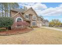 Charming two-story home with stone accents, a well-maintained lawn, and a two-car garage at 4118 Kentmere Main Nw, Kennesaw, GA 30144