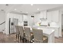 Bright kitchen features white cabinets, stainless steel appliances, and a large center island at 2855 Mcmurtry St, Cumming, GA 30041