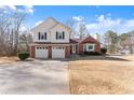 Charming two-story home with a brick and vinyl exterior and dormant lawn at 6920 Greenfield Ln, Cumming, GA 30028