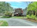 Scenic view of home surrounded by lush trees, a circular driveway, and well-maintained landscaping at 311 Maranatha Trl, Lawrenceville, GA 30045