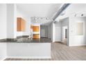 Open-concept kitchen featuring modern appliances, granite countertops, wood cabinets and track lighting at 5300 Peachtree Rd # 2309, Chamblee, GA 30341