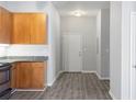 Compact kitchen area featuring wooden cabinets, granite countertops and wood-look flooring at 5300 Peachtree Rd # 2309, Chamblee, GA 30341