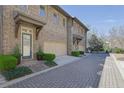 Street view of attached garage brick townhomes with professionally landscaped yards at 91 Webb St, Roswell, GA 30075