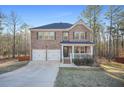 Charming two-story brick home featuring a two-car garage, covered porch, and manicured lawn at 13699 Inman Rd, Hampton, GA 30228