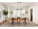 Formal dining room with wainscotting, a modern chandelier, and bright windows at 263 Mathews Ne Ave, Atlanta, GA 30307