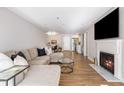 Open-concept living room with a fireplace, large TV, sectional sofa, and view into the kitchen at 3201 Lenox Ne Rd # 23, Atlanta, GA 30324