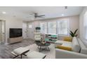 Staged living room with furniture, large windows, wood-look floors, neutral walls, and ceiling fan at 1256 Elizabeth Sw Ave, Atlanta, GA 30310