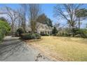 Lovely home featuring a well-kept lawn, a black gated driveway, and mature trees at 3391 Pinestream Nw Rd, Atlanta, GA 30327