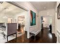 Elegant hallway with dark hardwood floors, decorative molding, a stylish bench, and views into other living spaces at 3391 Pinestream Nw Rd, Atlanta, GA 30327