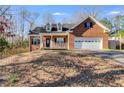 Traditional brick home featuring an attached garage and a cozy front porch at 121 Fox Wood Ct, Villa Rica, GA 30180
