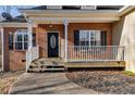 Close-up of the covered front porch with a decorative door and attractive landscaping at 121 Fox Wood Ct, Villa Rica, GA 30180
