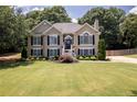 Charming two-story home featuring black shutters, a manicured lawn and inviting front entrance and manicured yard at 2515 Little John Ct, Cumming, GA 30040