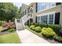 Inviting walkway to home's front entrance with flower beds and green shrubbery along the sidewalk to the stairs at 2515 Little John Ct, Cumming, GA 30040