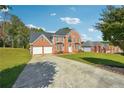 Brick home featuring a long driveway and lush green lawn at 93 Carriage Lake Dr, Stockbridge, GA 30281