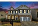 Charming two-story home with stone accents, a cozy front porch, and mature landscaping under a colorful dusk sky at , Atlanta, GA 30318